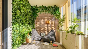 A cozy reading nook with a wall of greenery, two bean bags, a small table with drinks, and a book on a tiled floor. - Apartments & SPA Posesja Plażowa Grzybowo by POSESJA APARTAMENTY 4a I (Grzybowo)