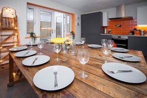Enjoy a warm and inviting dining experience in this beautifully set room, complete with a modern kitchen and comfortable seating.