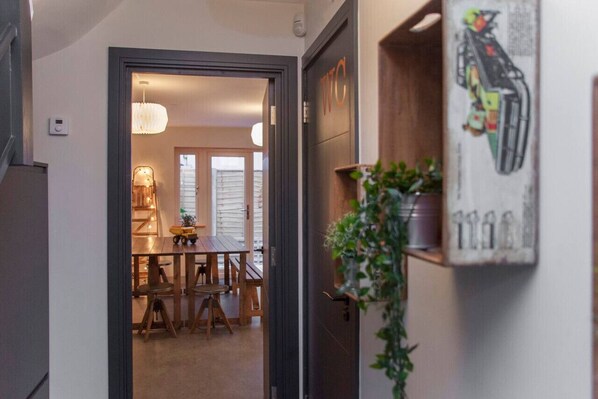Enter a warm and inviting space, featuring a dining area with a wooden table and chairs.