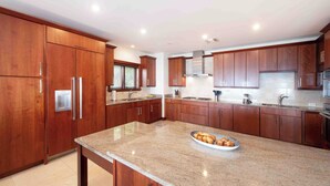A modern kitchen with wooden cabinets, stainless steel appliances, and a granite countertop.