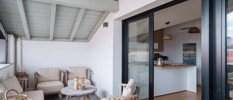 Un interior moderno con zona de comedor, sofás, cocina y puerta de vidrio que da a la cocina.