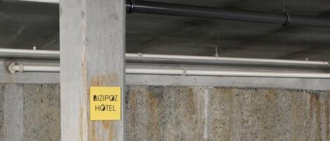 Un pilier en béton sur lequel est apposée une enseigne indiquant « Bizipoz Hotel », et un étage portant le numéro « 07 ».