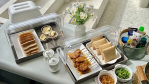 A breakfast buffet setup with various food items and condiments.