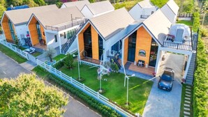 Un moderno complejo residencial con varias casas que cuentan con amplios ventanales, un patio central y vistas del paisaje circundante.