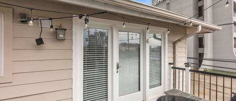 A house with a covered porch, a welcome mat, and a small table.