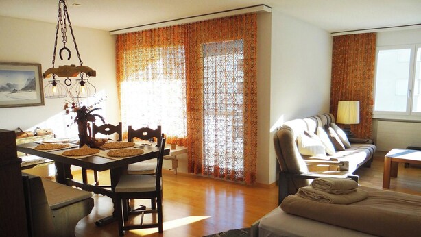 Une chambre d’hôtel équipée d’une table à manger, de chaises, d’un canapé, d’un lit et d’une lampe.