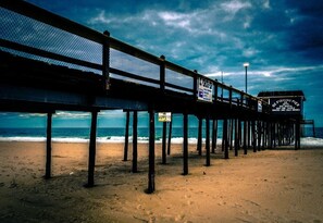 A pier extending over a beach with a sign advertising a fishing pier and seafood. - 3 bedroom - Bayview with outdoor pool (Ocean City)