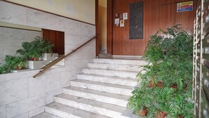 A staircase with marble steps, wooden handrails, and potted plants. - Balcony Flat Near the Center by Wonderful Italy (Sanremo)