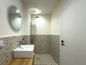 Deluxe studio suite | Badkamer | Een douche,  milieuvriendelijk toiletgerief, een haardroger, handdoeken