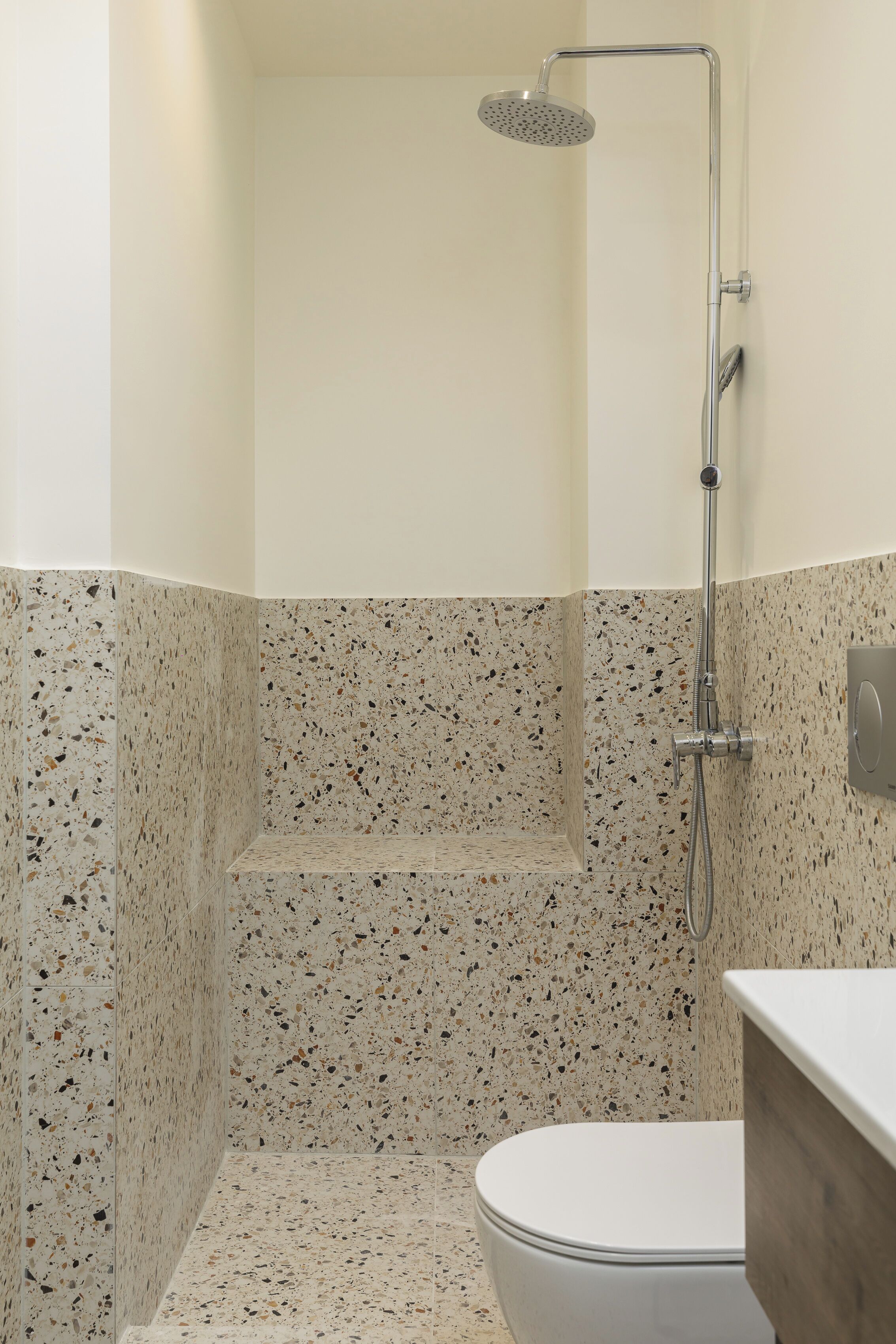 A modern bathroom with a shower, a toilet, and a vanity.