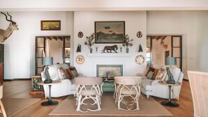 A living room with a fireplace, two sofas, and decorative items. - Rosemary Room (Póvoa de São Miguel)