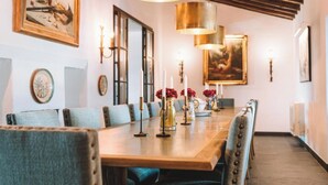 A long dining table with multiple chairs, candles, and vases with flowers. - Rosemary Room (Póvoa de São Miguel)