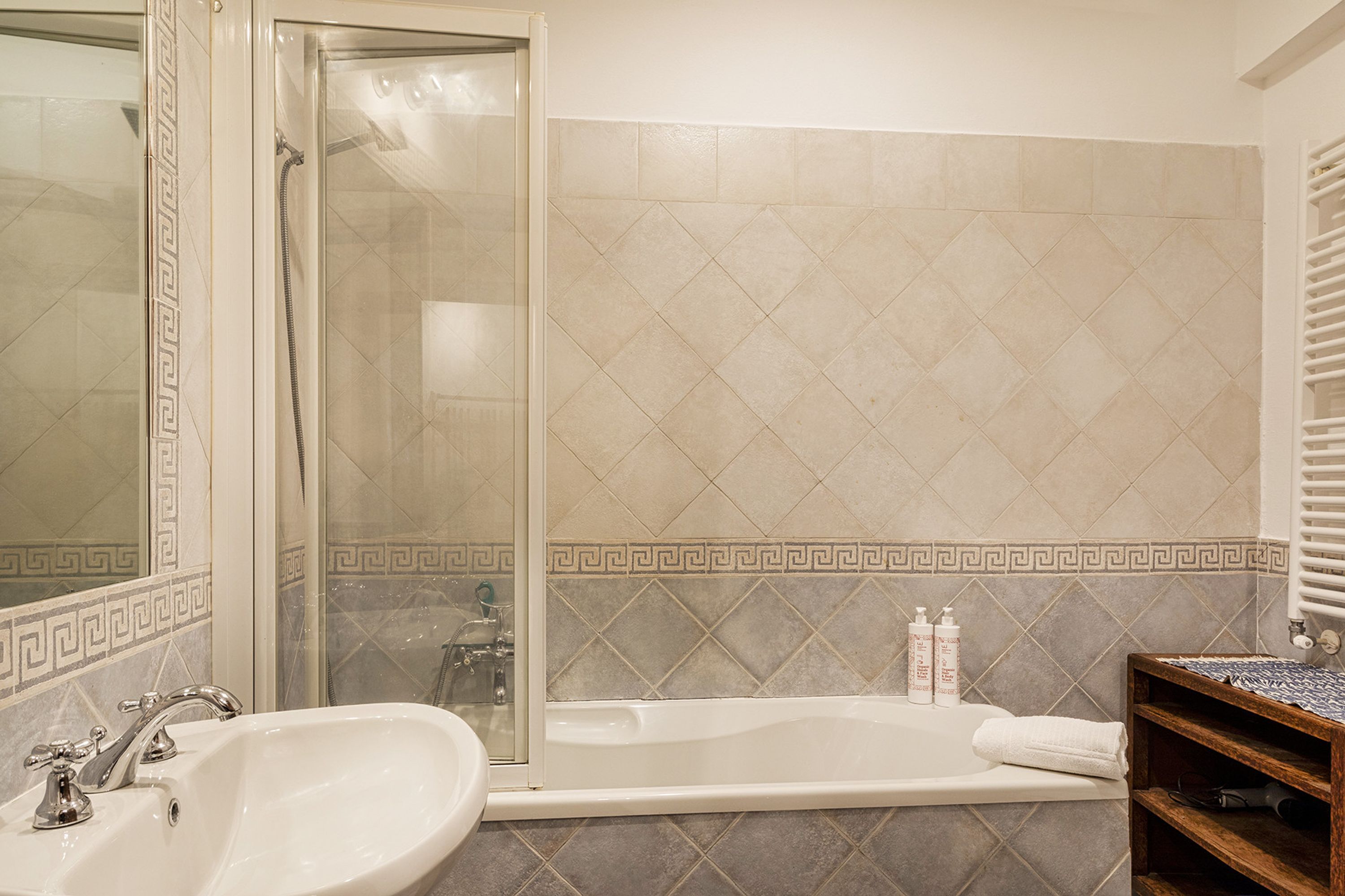 A bathroom with a bathtub, a shower, and a sink.