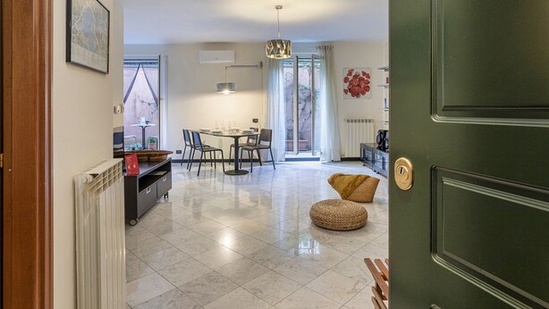 Un vaste espace de vie comprenant une table à manger, des chaises, un canapé et une porte verte.