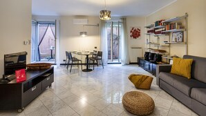 Un salon moderne comprenant un canapé, une table basse et un coin repas avec une table et des chaises.
