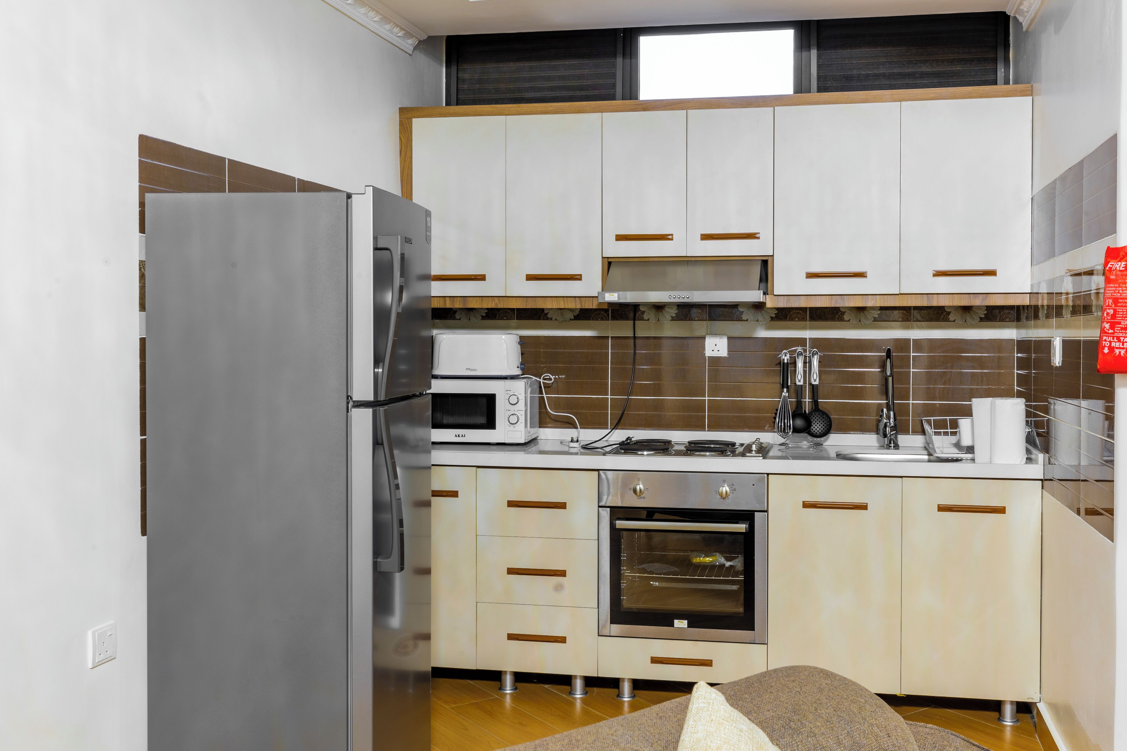 Cocina compacta con refrigerador, microondas, horno y lavamanos.