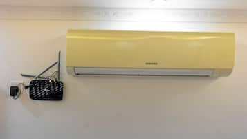 A wall-mounted air conditioner with a control panel and a power cord.