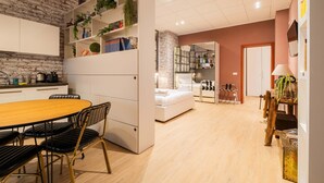 Un espace de vie compact comprenant une cuisine, un coin repas et une chambre.