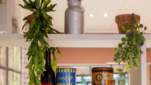 Une étagère contenant divers objets, notamment une bouteille, une boîte de conserve, un récipient en métal et une plante en pot.