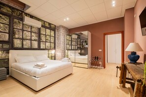 A modern bedroom with a large bed, a wooden nightstand, a mirror, and a wooden table with a lamp. - Casa Polese in Bologna (Bologna)