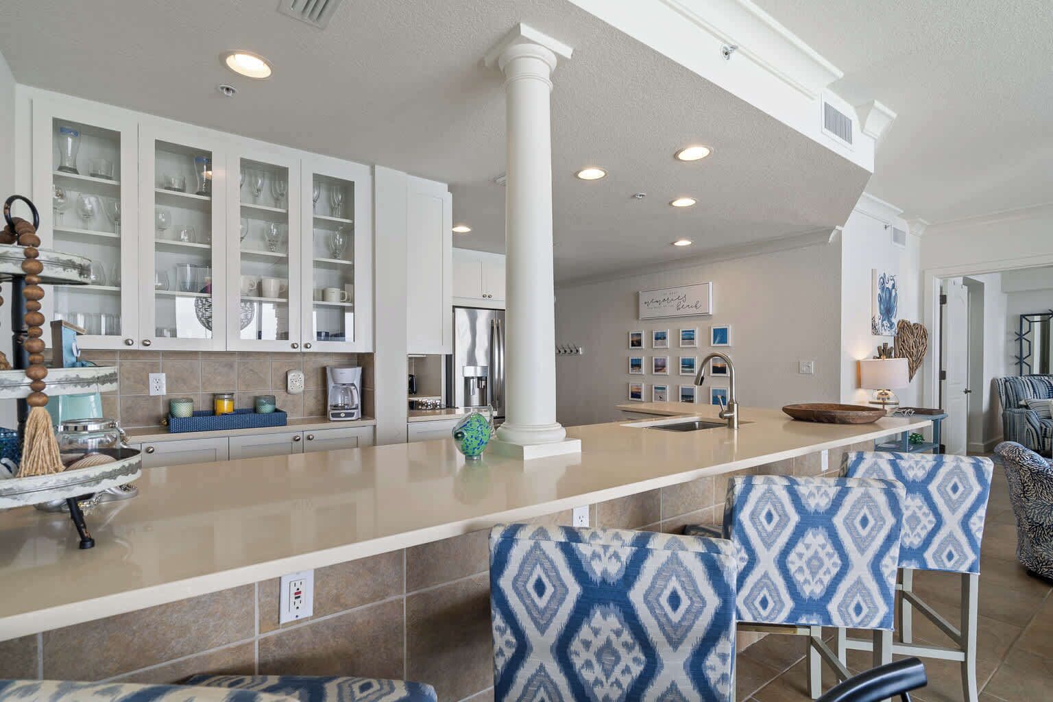 Una cocina amplia con una isla central, muebles blancos y un diseño moderno.