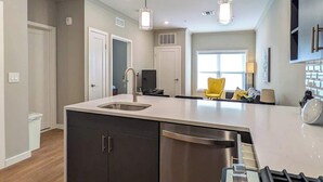 A modern kitchen with a central island, stainless steel appliances, and pendant lighting. - 329 Modern 1BR Apt Walk to NJT (Dunellen)
