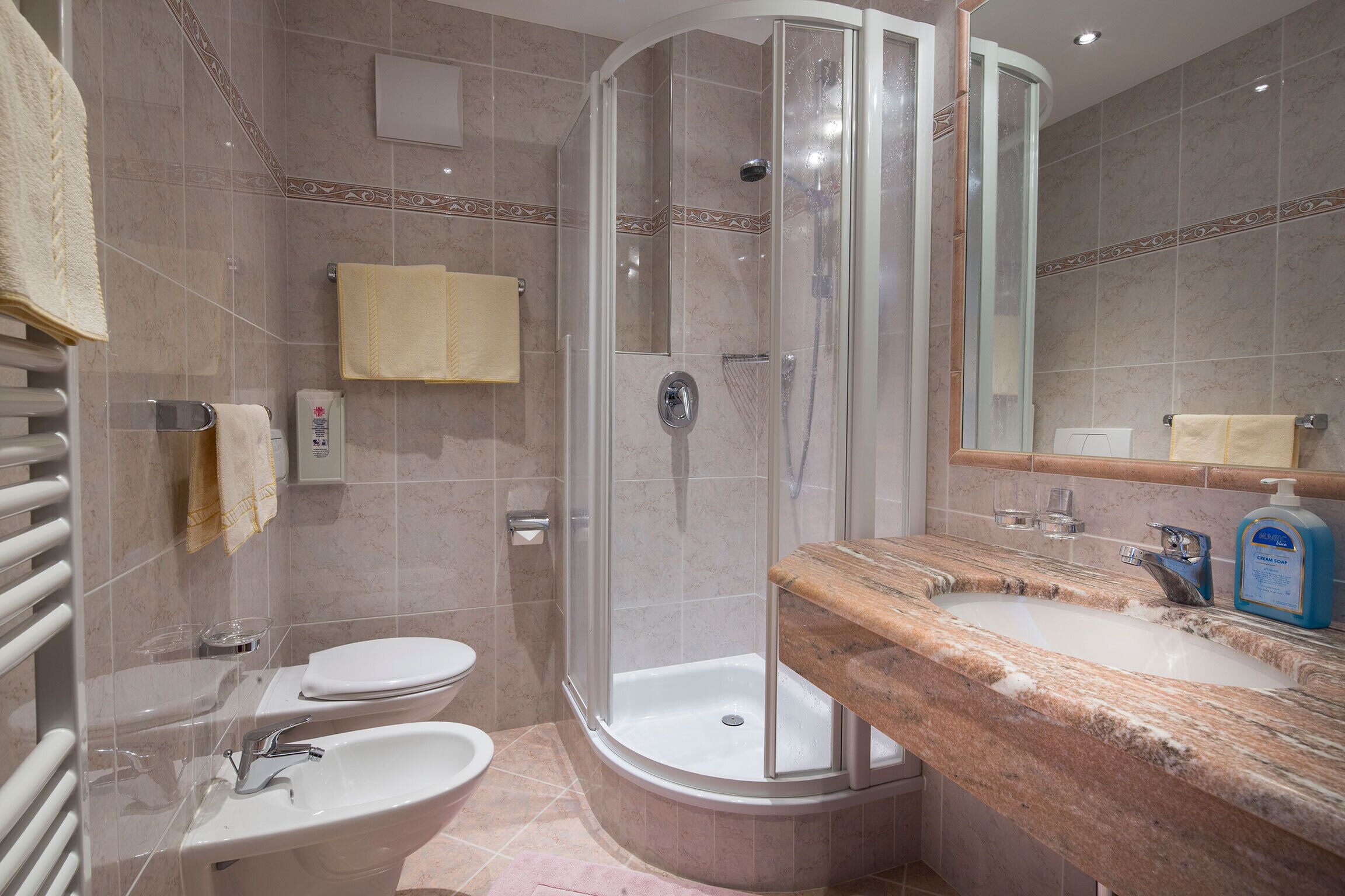 Ein modernes Badezimmer mit einer Duschkabine aus Glas, einem Waschbecken und einer Toilette.