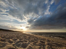 En strand med et stort sandområde og udsigt til havet.
