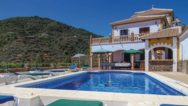 Um hotel com piscina, área de estar externa e vista para uma paisagem montanhosa.