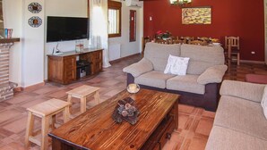 Uma sala de estar com sofá, mesa de centro e televisão.