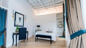 Une chambre à coucher comprenant un lit, une table de chevet, une chaise et un bureau avec une lampe.