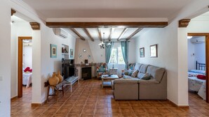 Ein geräumiges Wohnzimmer mit Kamin, einer Couch und einem Fernseher.