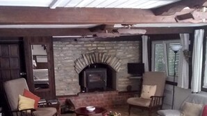 A cozy living room with a stone fireplace, comfortable seating, and a television. - Private cottage with it's own fishing & pet friendly! (Civray)