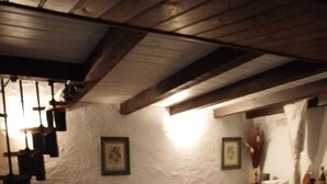 A dining area with a table set for four, wooden chairs, a white tablecloth, and a rustic ceiling. - Private cottage with it's own fishing & pet friendly! (Civray)