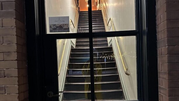 Eine Treppe, die zu einer oberen Etage führt, mit einer Fußmatte mit der Aufschrift 'WELCOME' am unteren Ende.