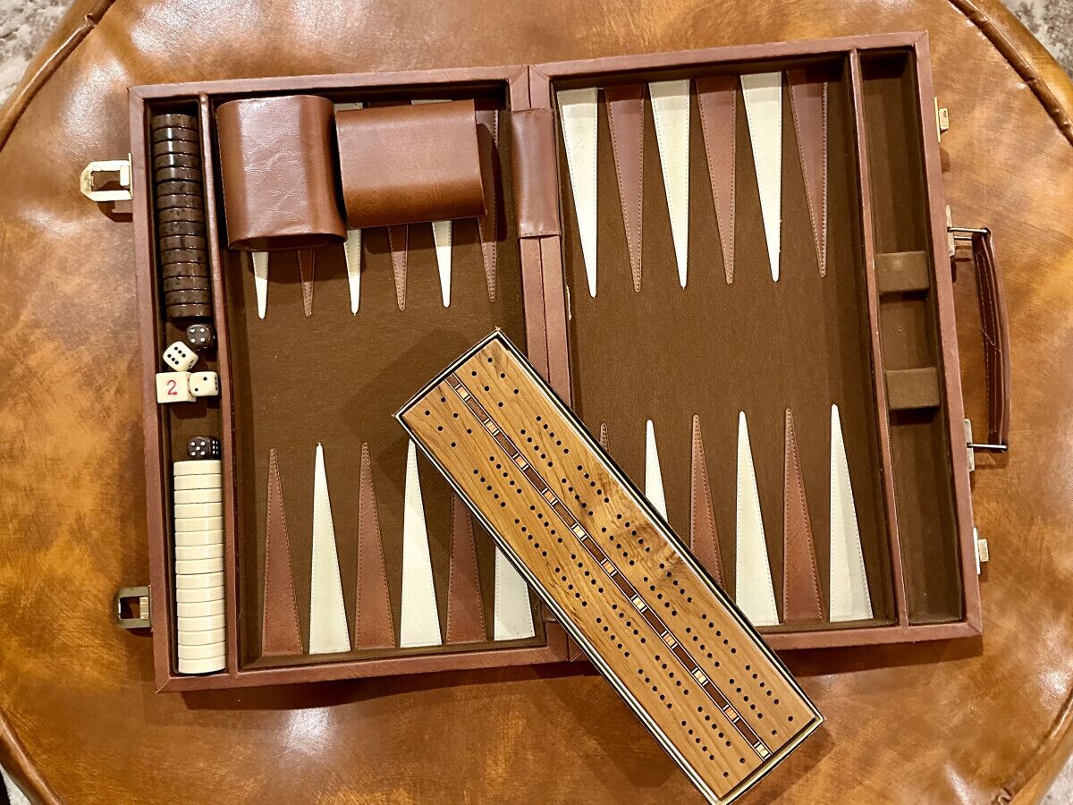 A brown leather case with dice, a ruler, and triangular tools.