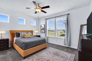 A bedroom with a bed, a ceiling fan, a window with curtains, a nightstand, and a dresser. - Gorgeous 2 BDR Cottage Minutes to Everything NBTX! (New Braunfels)