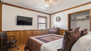 A bedroom with a bed, a desk, a chair, a television, a ceiling fan, and a window with blinds. - 4BR Glendale Ranch - Family & Horse Friendly! (Glendale)
