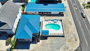 Une propriété résidentielle dotée d’une piscine, d’un patio couvert et donnant sur la rue.