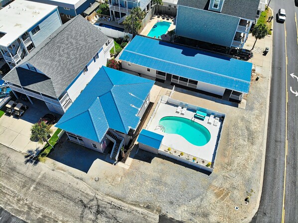 A residential area with multiple houses, each featuring a swimming pool and a covered patio area.