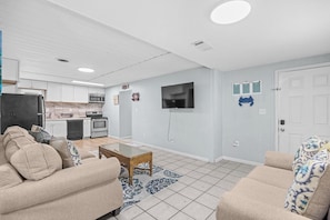 A modern living room with a sofa, coffee table, and a television.