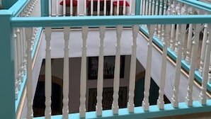 A staircase with turquoise railings and white balusters, leading to a balcony with a red cushion and a table. - Riad Darko  (Essaouira)