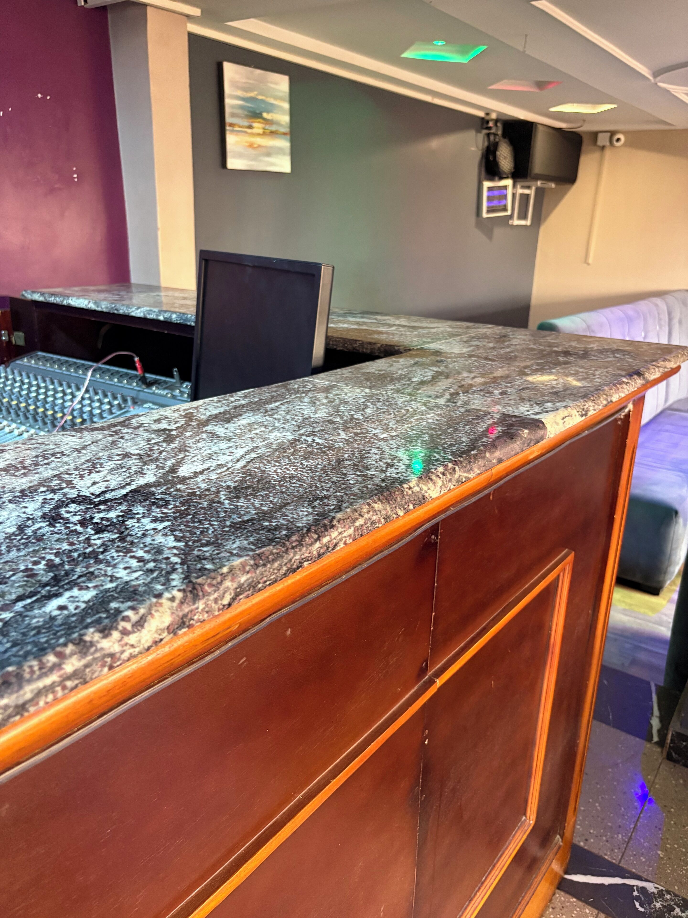 A wooden reception desk with a granite top, a computer monitor, and a keyboard.