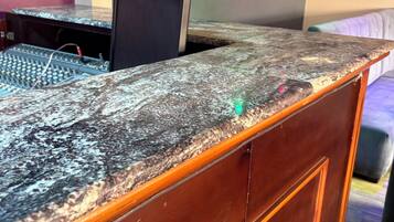 A wooden reception desk with a granite top, a computer monitor, and a keyboard.