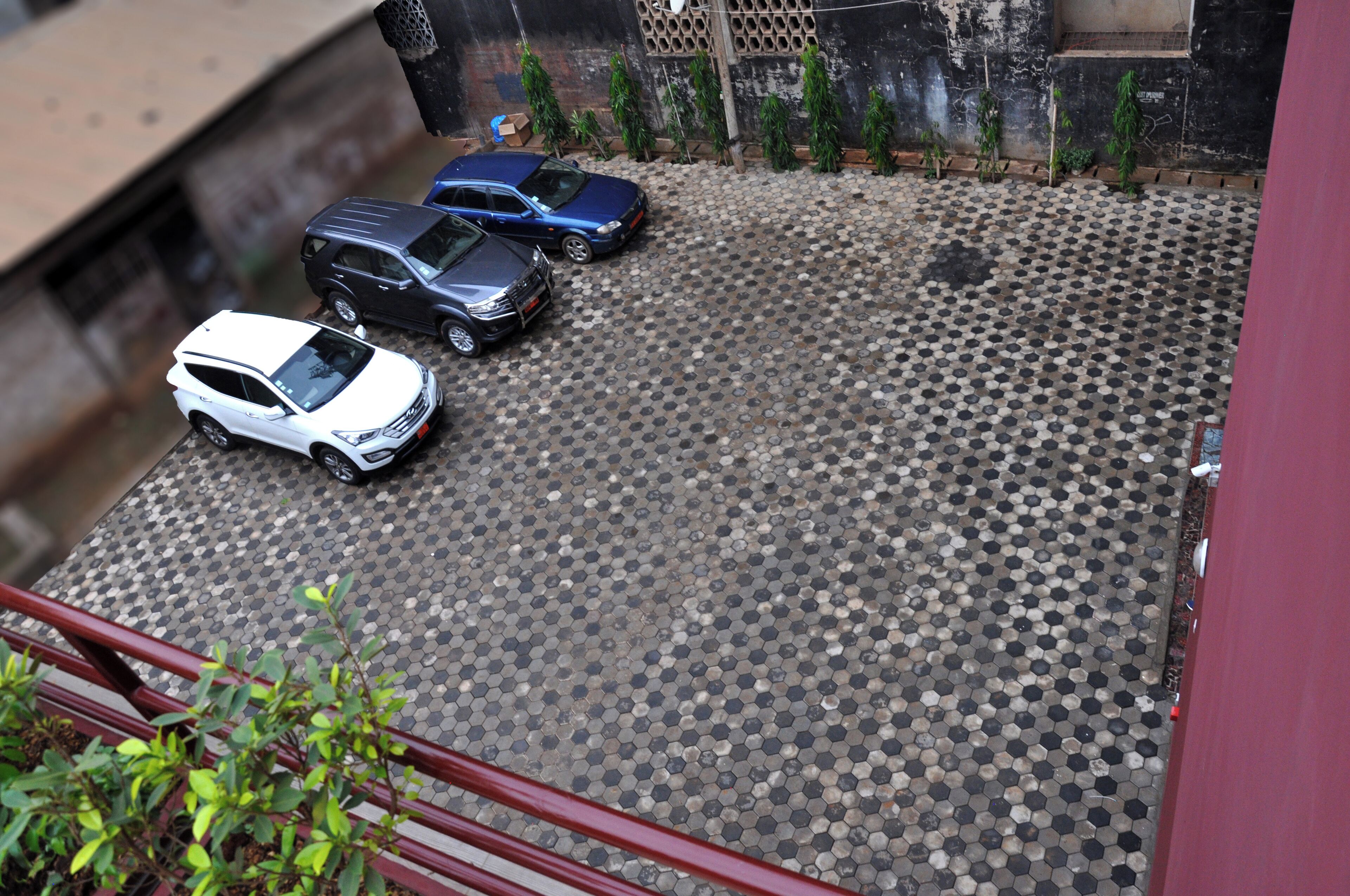 Uma área de estacionamento com três carros e um piso estampado.