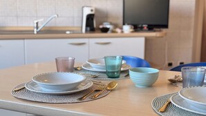 A modern kitchen with white cabinets, a coffee maker, and a television on the counter. - Il Giardino Delle Farfalle by Ca-sa Check (Chioggia)
