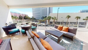 A balcony with outdoor furniture, including sofas, a table, and chairs.