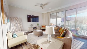 Una sala de estar moderna con un sofá, sillones, una mesa de centro y un televisor. Cuenta con un balcón y vistas.