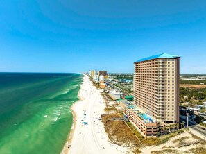A beachfront hotel with multiple floors, a pool, and a beach view.