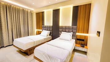 Habitación de hotel con dos camas, ventilador de techo y diseño moderno.